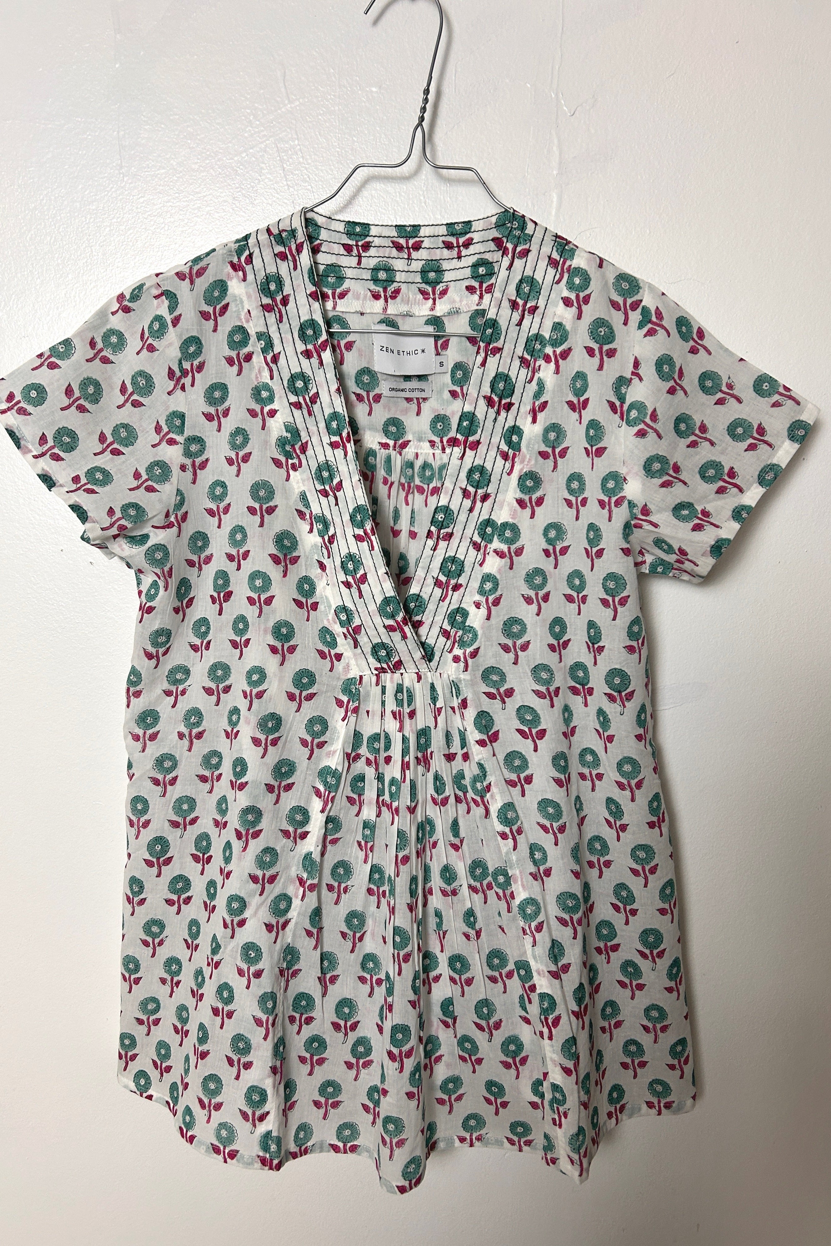 White summer top with graphic green floral print